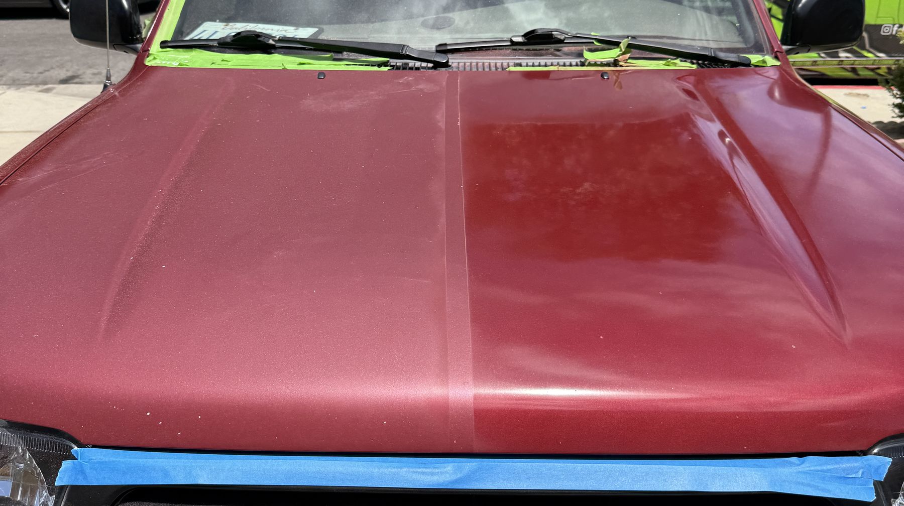 Red truck hood taped down the middle: the left half before, the right half after
